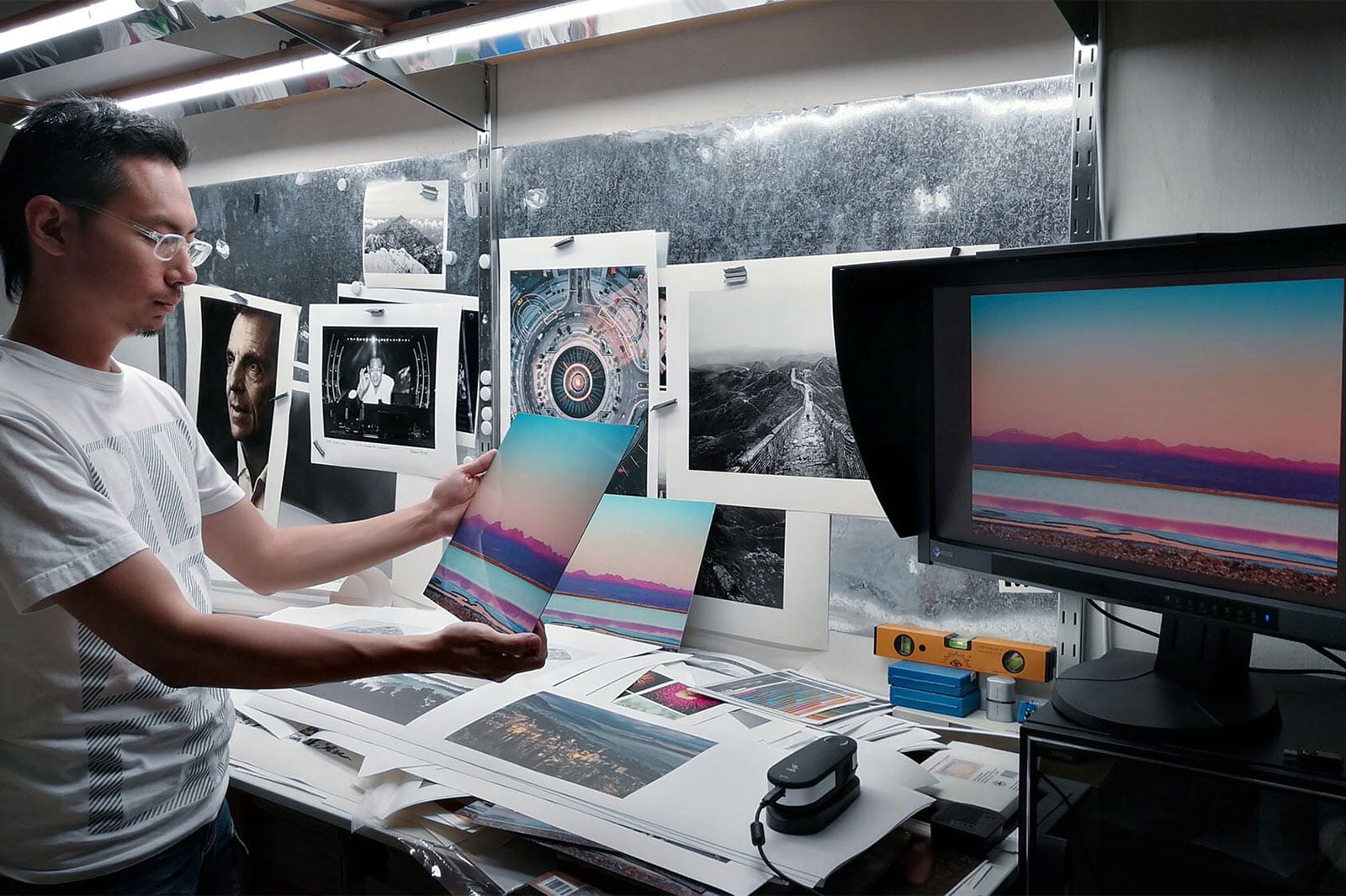 Printmaker James Tan compares a metal dye sublimation print of a sunset to the photo on a monitor.
